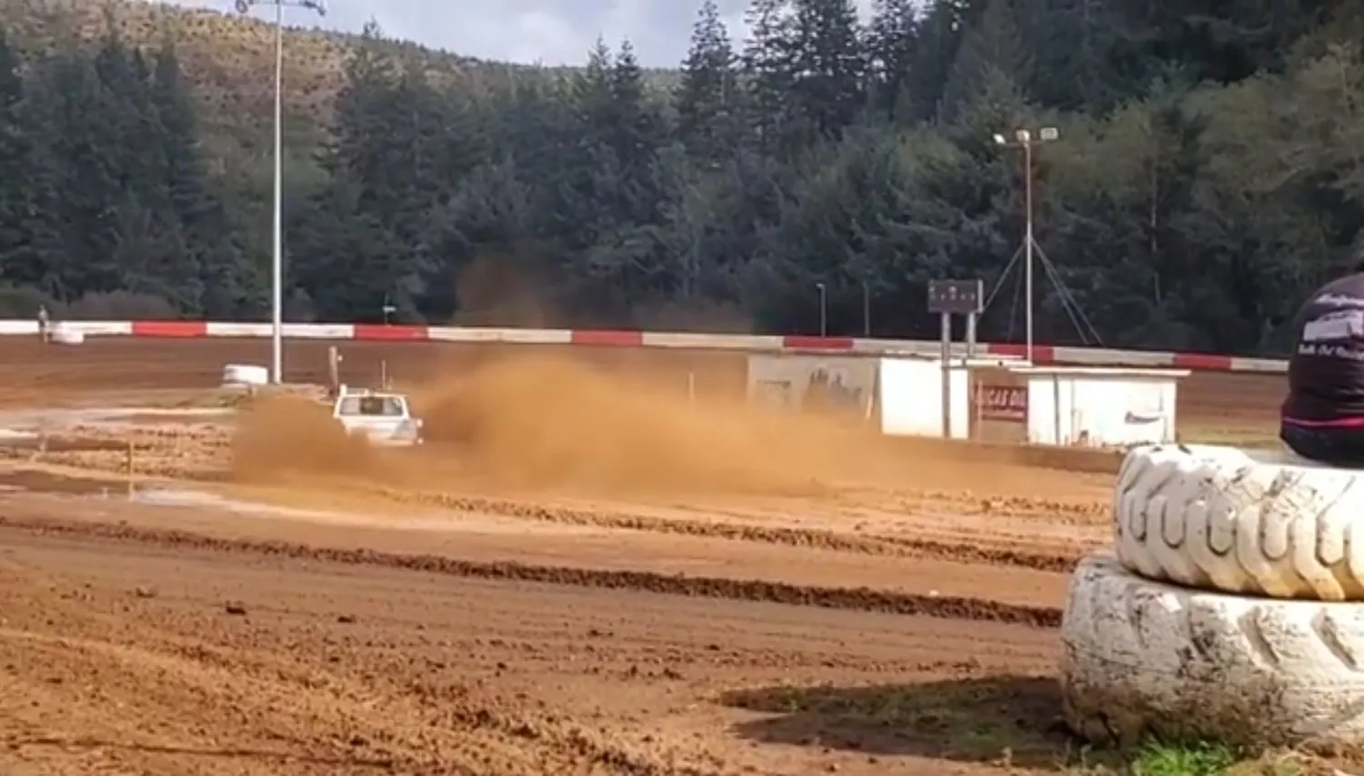 A car throwing a big cloud of dirt on the Coos Bay oval